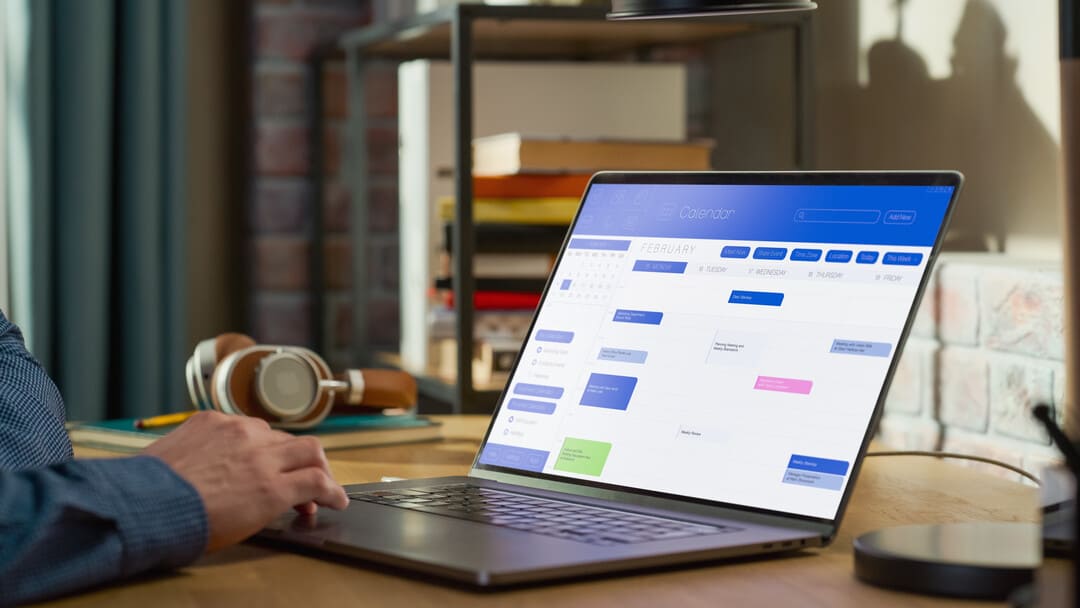 Homem organizando fluxo de trabalho no notebook por meio do Google Workspace.