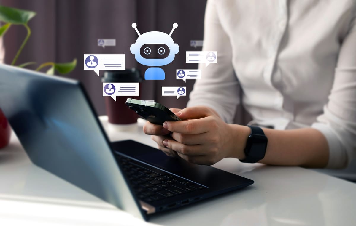 Pessoa interagindo com chatbot-marketing em celular e notebook.