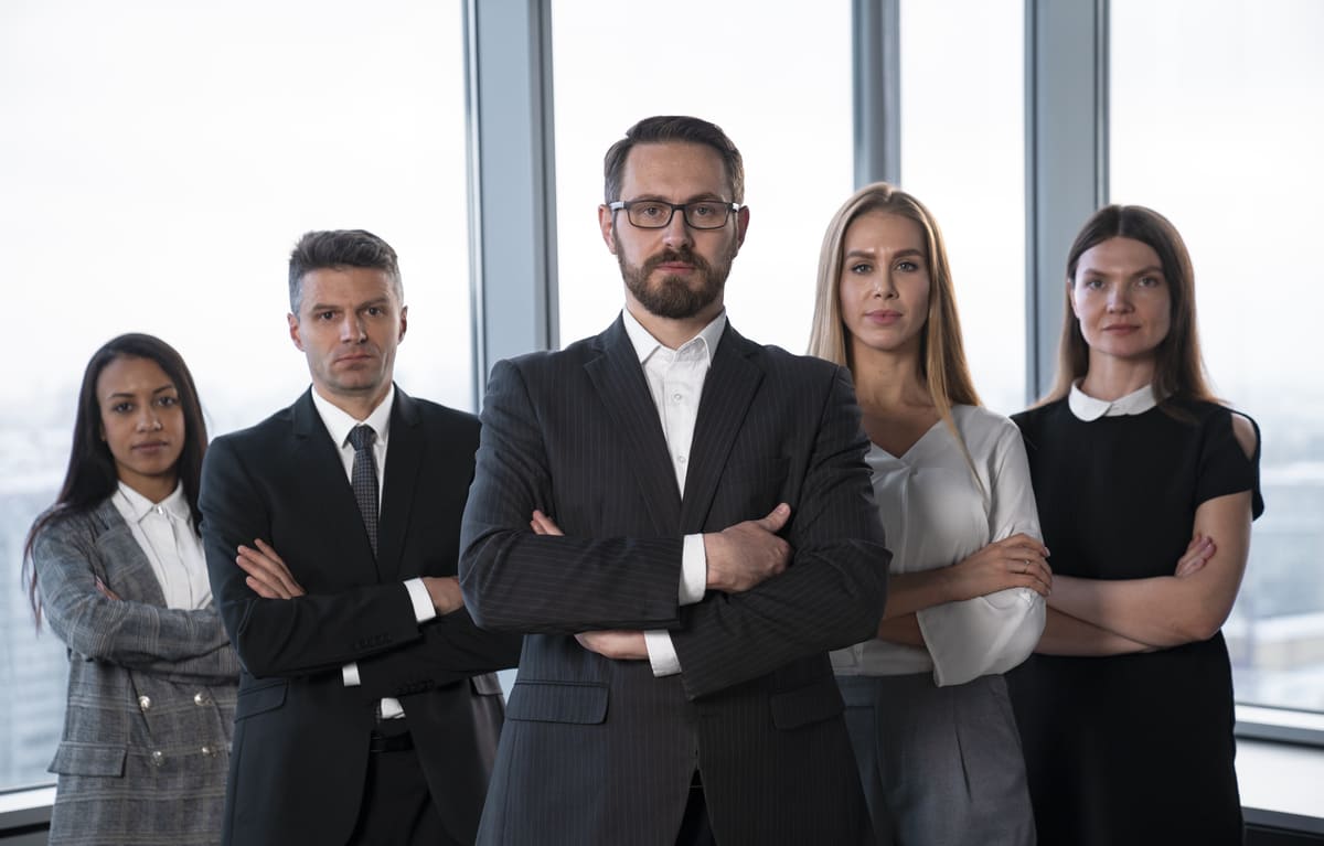 Executivos de braços cruzados lado a lado, representando o conceito de pessoa politicamente exposta.