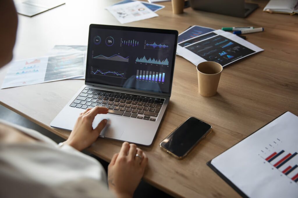 Líder usando o notebook com dados expostos na tela para uma tomada de decisão mais efetiva, graças à transformação digital